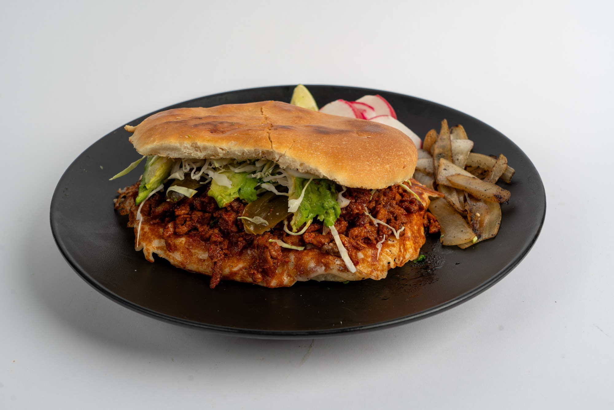 Mexican torta sandwich with meat avocado and fresh vegetables